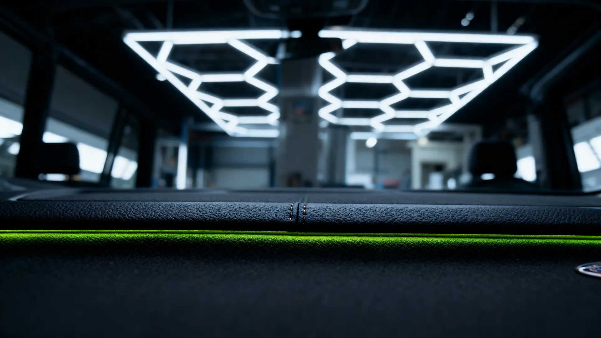 Faint lime glow behind the dashboard of a dark luxury SUV cabin